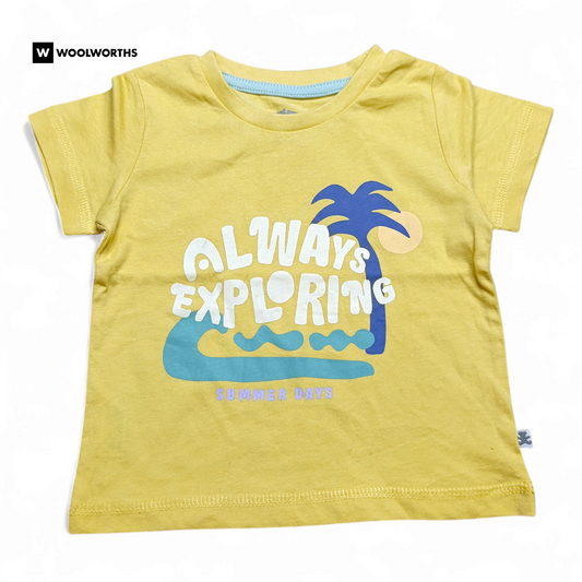Yellow t-shirt with 'Always Exploring' text and palm tree graphic on a white background, branded with Woolworths.